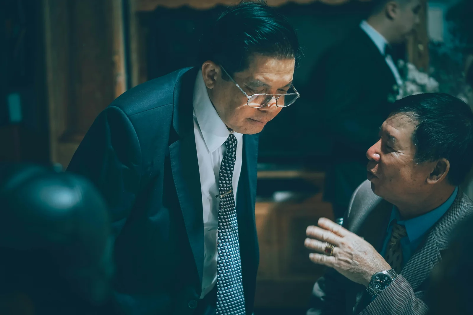 Two suited professionals listening closely and exchanging ideas in conversation.