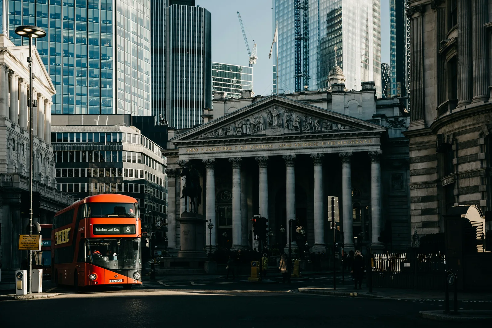 Classical stone architecture and modern towers along a London street.